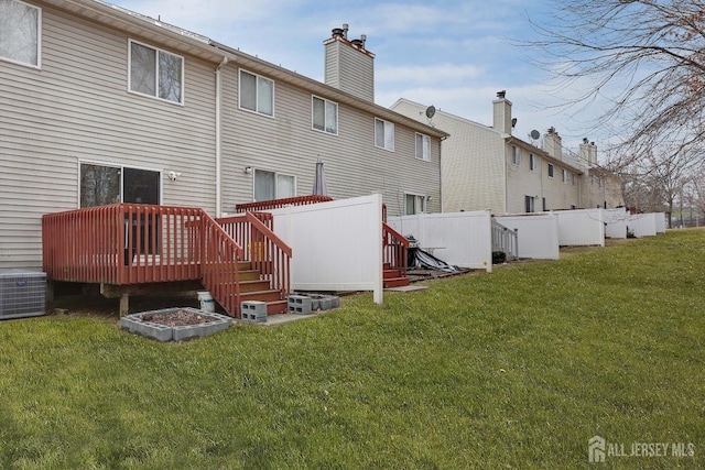 back of house with cooling unit, fence, a chimney, a deck, and a lawn