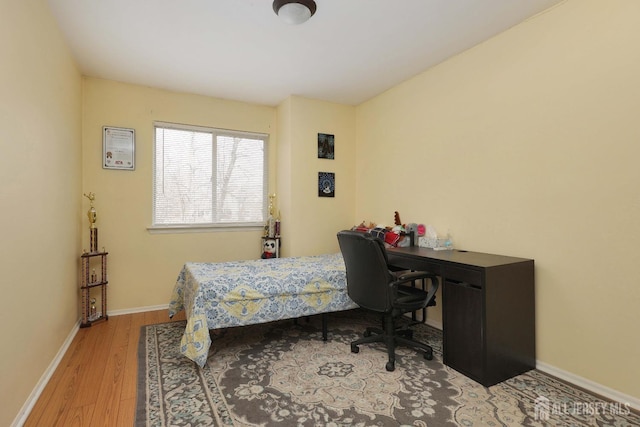 bedroom with baseboards and wood finished floors