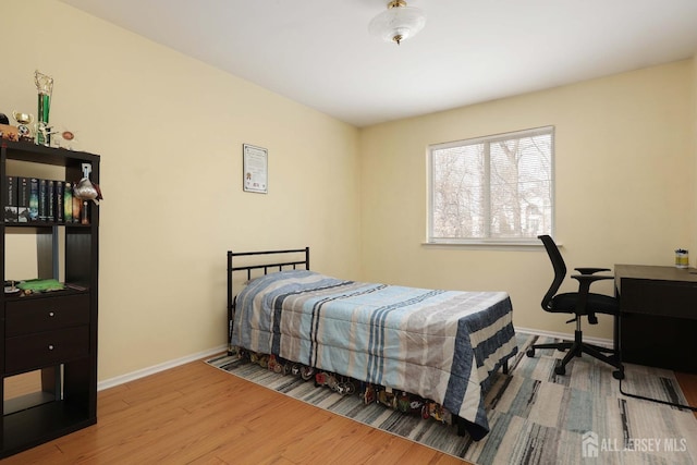 bedroom featuring wood finished floors and baseboards