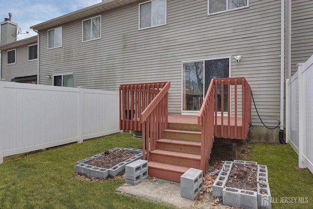 back of house with a garden, a lawn, and a fenced backyard