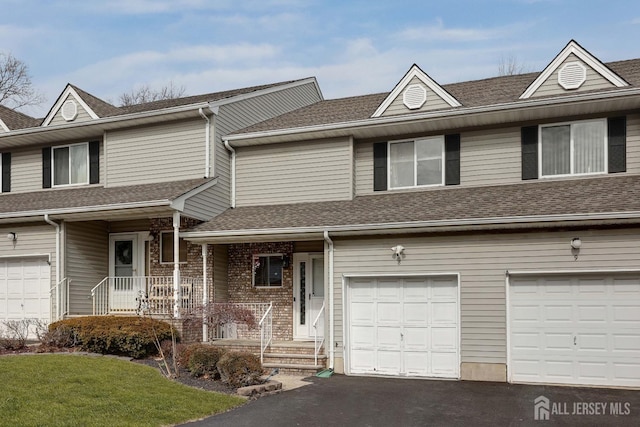 view of front of house featuring brick siding, driveway, a shingled roof, and a garage