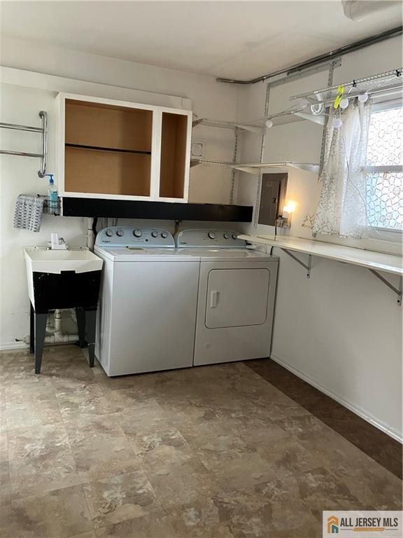 laundry area featuring laundry area, electric panel, and washer and clothes dryer