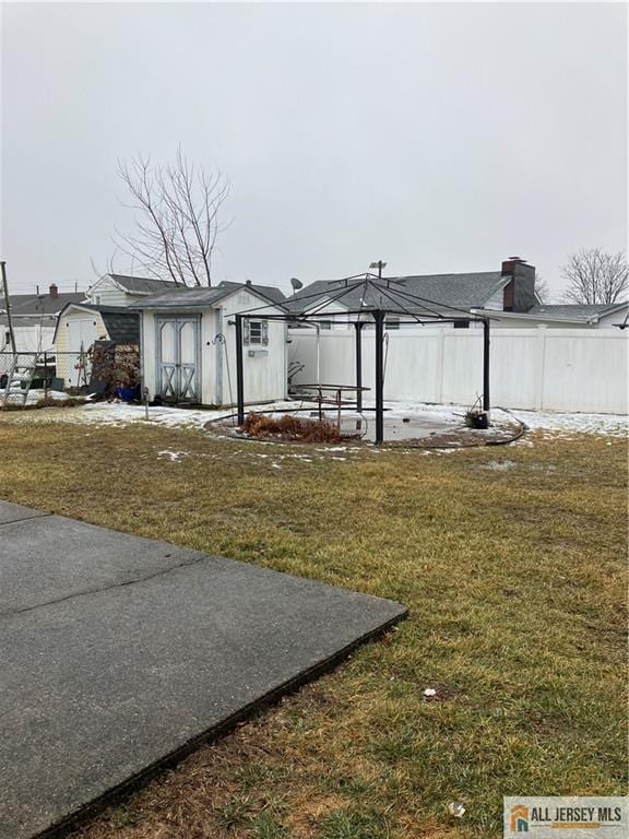 view of yard featuring an outbuilding, a shed, and fence