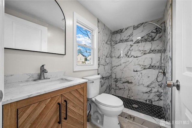 bathroom featuring toilet, a shower stall, and vanity