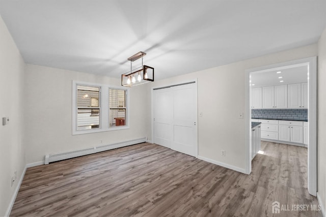 interior space with light wood-style floors, baseboards, and baseboard heating