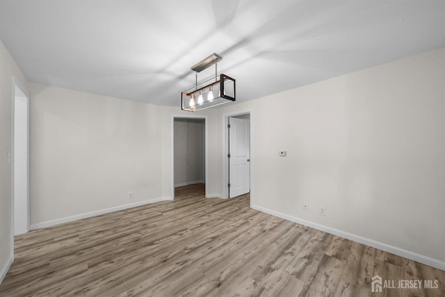 empty room with light wood-style floors and baseboards