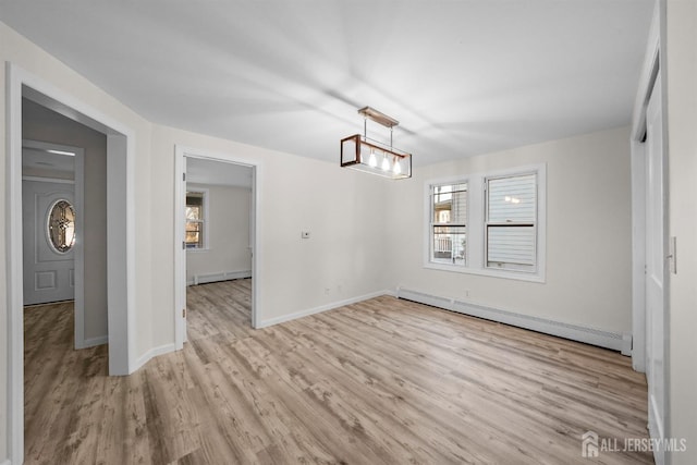 unfurnished dining area with light wood finished floors, a baseboard radiator, and a healthy amount of sunlight