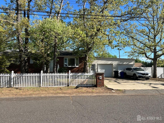 24 Kensington Ave, Old Bridge, NJ 08857 - view of front of house featuring a garage, driveway, a fenced front yard, and brick siding