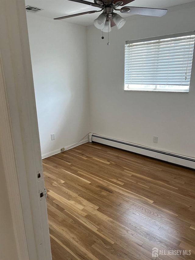 24 Kensington Ave, Old Bridge, NJ 08857 - unfurnished room with a baseboard heating unit, ceiling fan, wood finished floors, and baseboards