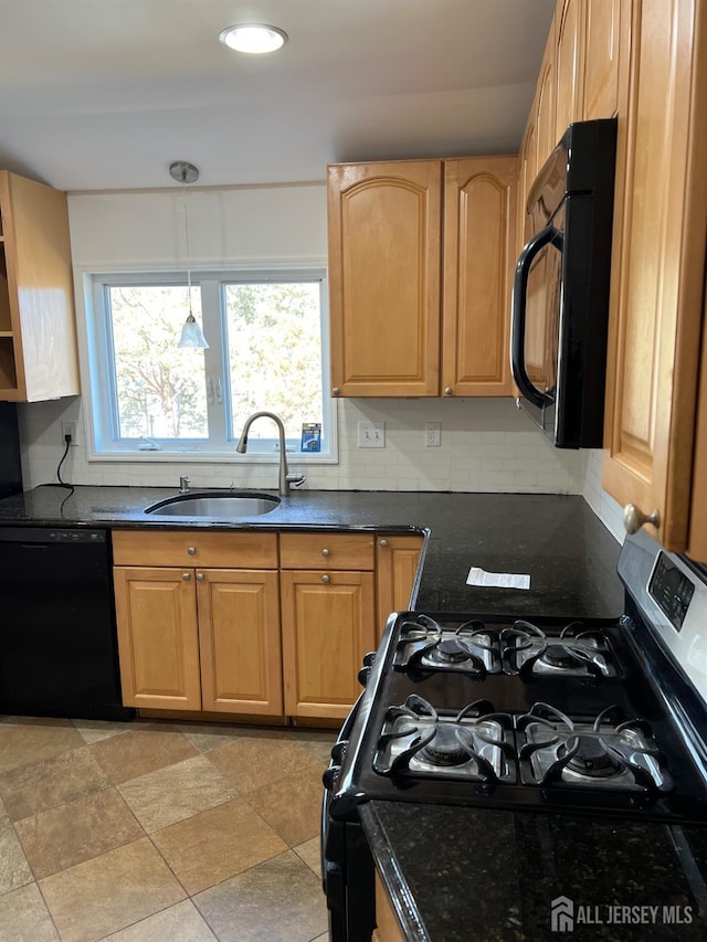 kitchen featuring dark stone countertops, sink, decorative light fixtures, black appliances, and decorative backsplash