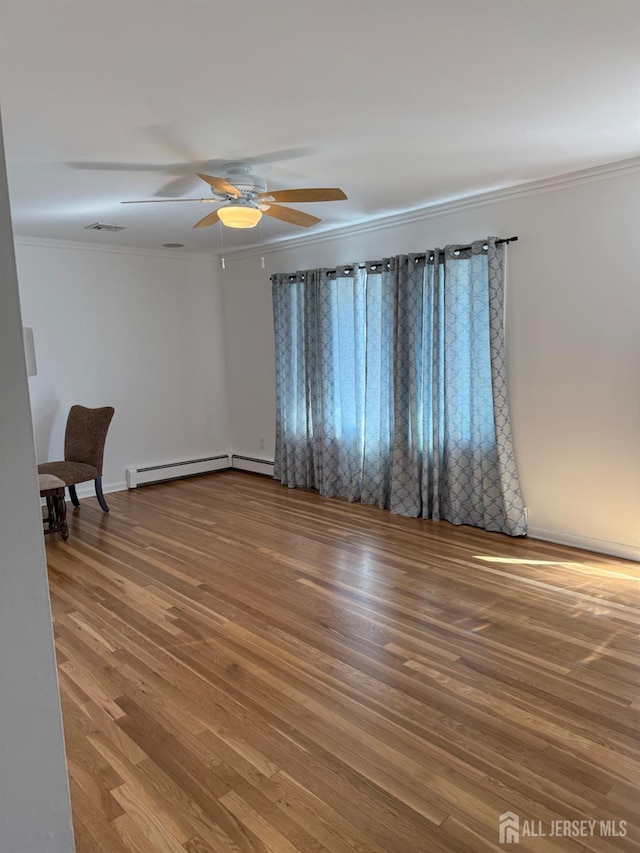 24 Kensington Ave, Old Bridge, NJ 08857 - empty room with ornamental molding, wood finished floors, a ceiling fan, a baseboard heating unit, and baseboards
