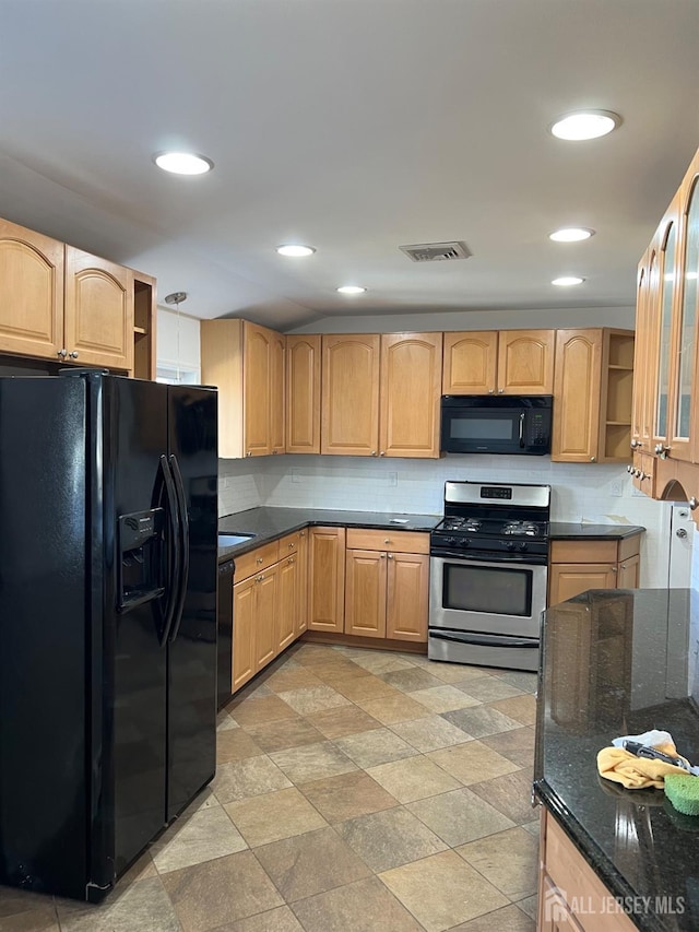 kitchen featuring dark stone counters, light brown cabinets, black appliances, and backsplash