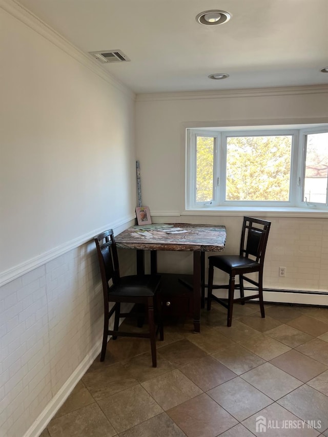 dining space with a baseboard heating unit, crown molding, and breakfast area