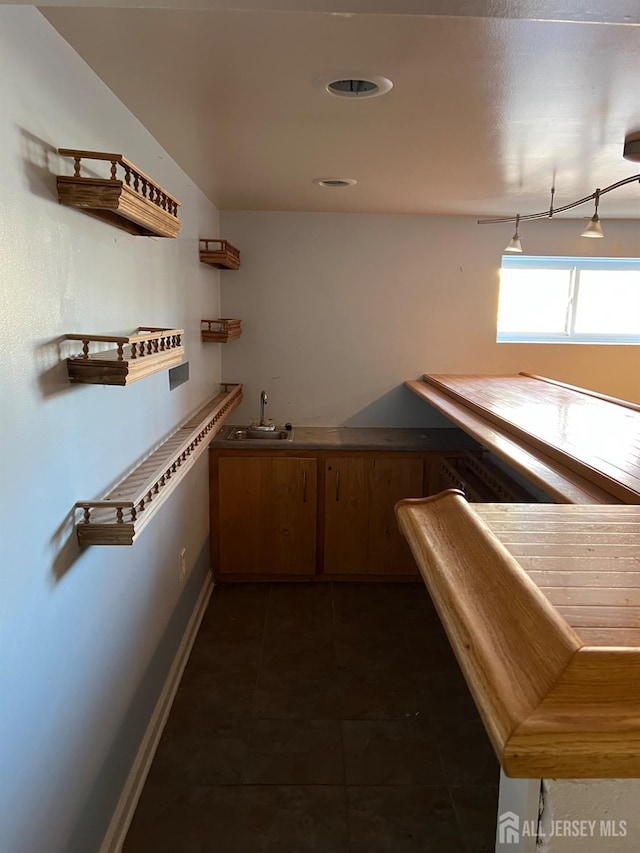 bar featuring sink and dark tile patterned floors