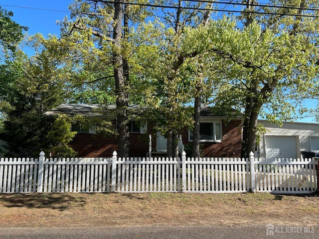 24 Kensington Ave, Old Bridge, NJ 08857 - obstructed view of property featuring a fenced front yard, an attached garage, and brick siding