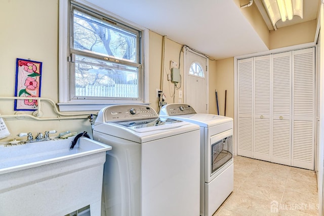 washroom with washing machine and clothes dryer, laundry area, light tile patterned flooring, and a sink