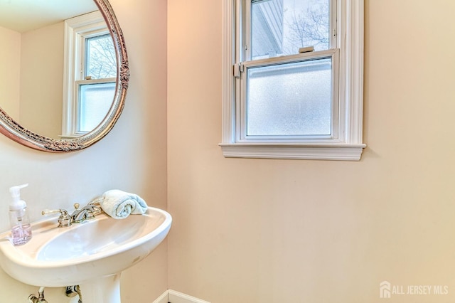 bathroom with a sink and baseboards