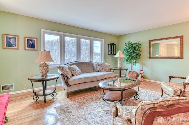 living area with visible vents, baseboards, and wood finished floors