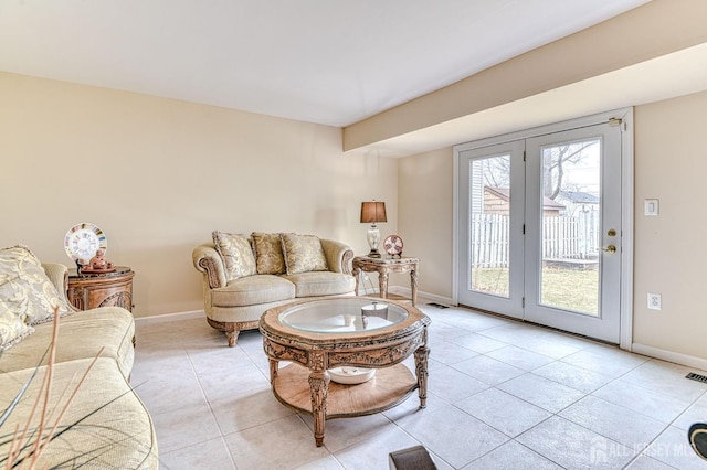 living room featuring light tile patterned floors, visible vents, and baseboards