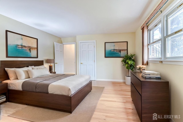 bedroom with light wood-style flooring and baseboards