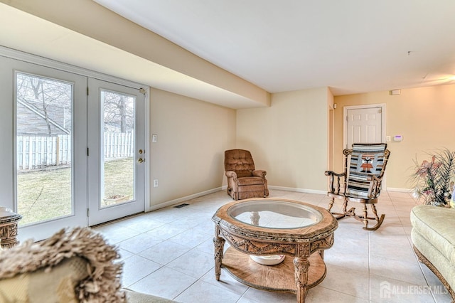 living area with light tile patterned floors, visible vents, and baseboards