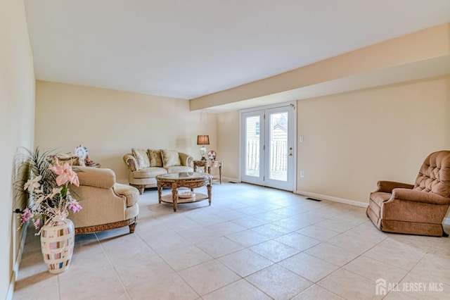 living room featuring light tile patterned floors, visible vents, and baseboards