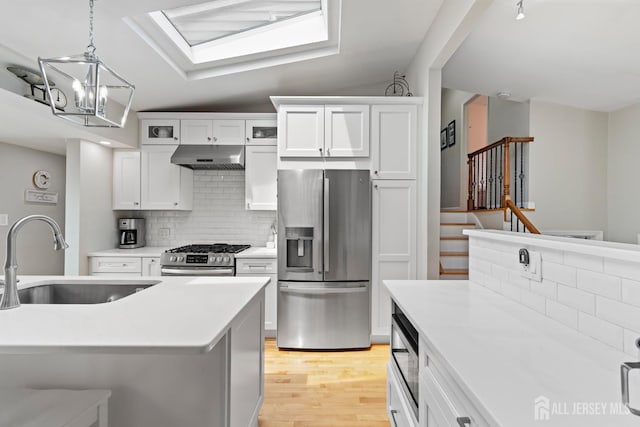 27 York St, Old Bridge, NJ 08857 - kitchen featuring appliances with stainless steel finishes, under cabinet range hood, tasteful backsplash, and light countertops