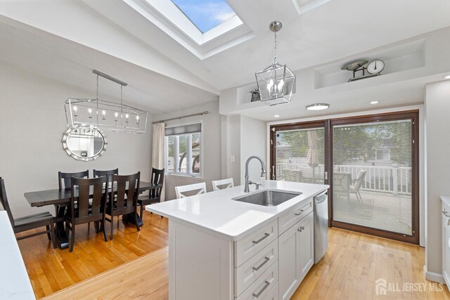 27 York St, Old Bridge, NJ 08857 - kitchen with a skylight, a chandelier, stainless steel dishwasher, light countertops, and light wood-style flooring