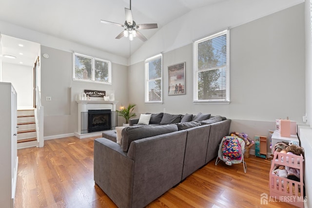 27 York St, Old Bridge, NJ 08857 - living room with ceiling fan, light wood-style floors, lofted ceiling, a fireplace with raised hearth, and stairs