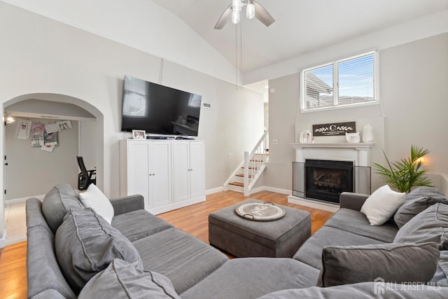 27 York St, Old Bridge, NJ 08857 - living room featuring light wood-style floors, ceiling fan, arched walkways, lofted ceiling, and stairway