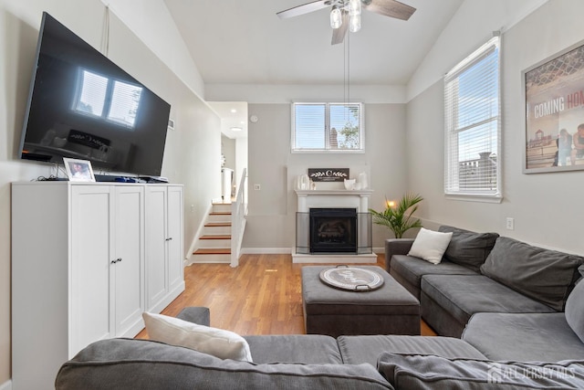 27 York St, Old Bridge, NJ 08857 - living room with healthy amount of natural light, light wood finished floors, vaulted ceiling, a ceiling fan, and a fireplace with raised hearth