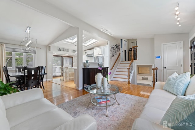 27 York St, Old Bridge, NJ 08857 - living room featuring light wood-type flooring, stairway, track lighting, lofted ceiling, and a chandelier