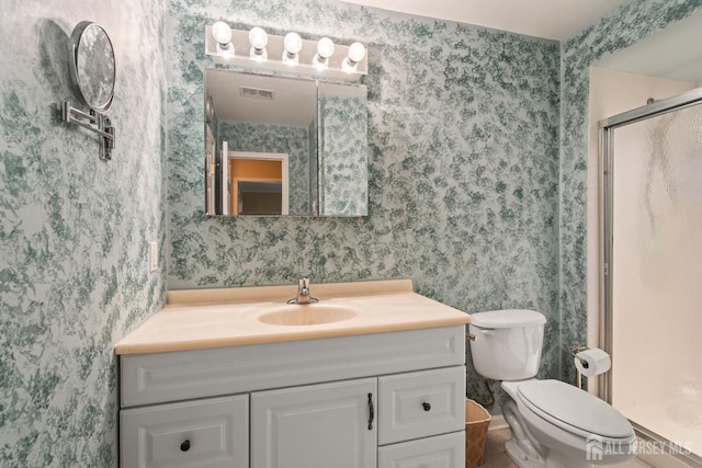 full bathroom featuring wallpapered walls, vanity, a shower stall, and toilet