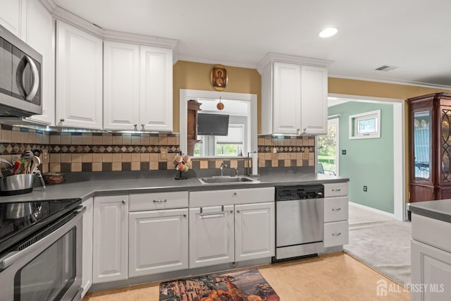 kitchen featuring stainless steel appliances, a sink, dark countertops, white cabinets, and backsplash