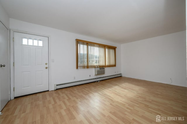 foyer entrance featuring light wood-style flooring, baseboard heating, and a wall mounted air conditioner