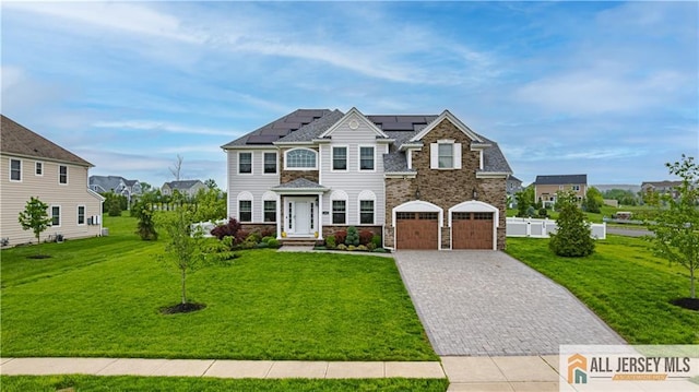 153 Scarborough Rd, Montgomery, NJ 08502 - view of front of property with decorative driveway, solar panels, a front lawn, stone siding, and an attached garage