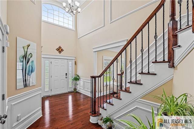 153 Scarborough Rd, Montgomery, NJ 08502 - foyer featuring a chandelier, a decorative wall, a high ceiling, wood finished floors, and wainscoting