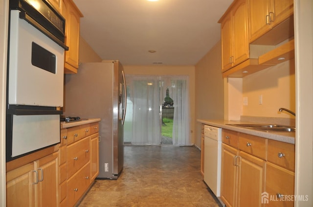 kitchen featuring a warming drawer, light countertops, a sink, and dishwasher