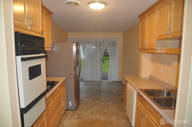 kitchen with a sink, white appliances, and light countertops