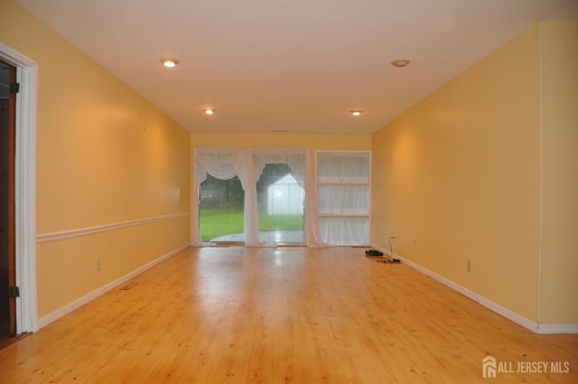 unfurnished room with recessed lighting, baseboards, and wood finished floors
