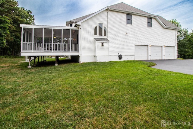 13 Carnegie St, Monroe, NJ 08831 - rear view of house with a sunroom, an attached garage, a yard, and driveway