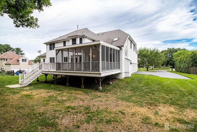 13 Carnegie St, Monroe, NJ 08831 - back of property with a sunroom, stairway, driveway, a lawn, and a garage