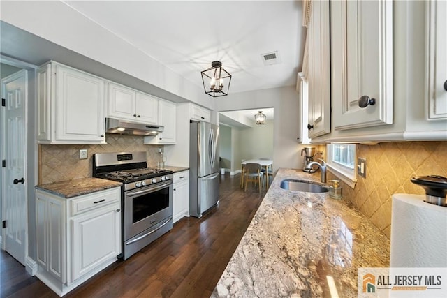 1072 Lake Placid Dr, Toms River, NJ 08753 - kitchen with appliances with stainless steel finishes, under cabinet range hood, tasteful backsplash, and light stone counters