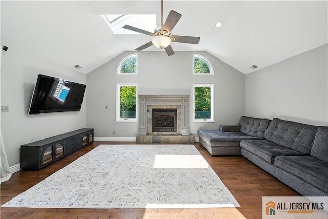 1072 Lake Placid Dr, Toms River, NJ 08753 - living area featuring ceiling fan, lofted ceiling, a skylight, a tiled fireplace, and dark wood finished floors