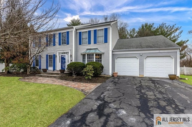 colonial inspired home featuring a front lawn and a garage