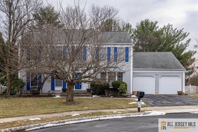 colonial house with a garage and a front yard