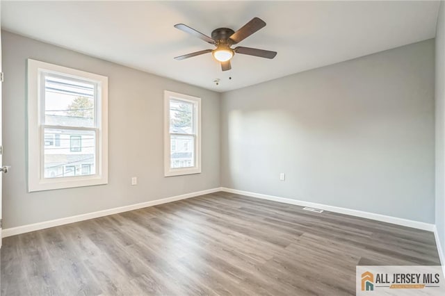 spare room with hardwood / wood-style floors and ceiling fan