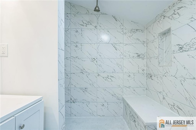 bathroom with vanity and tiled shower