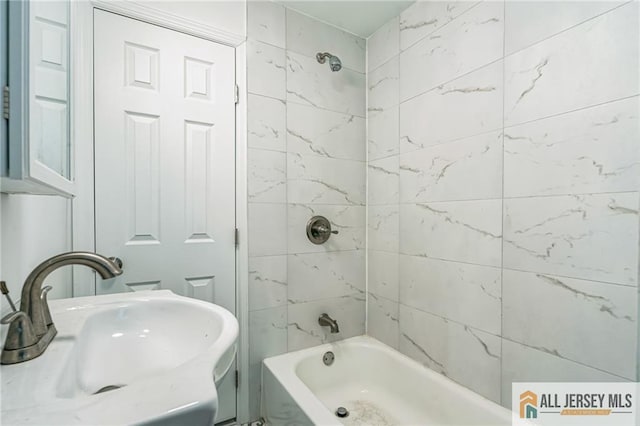 bathroom with sink and tiled shower / bath