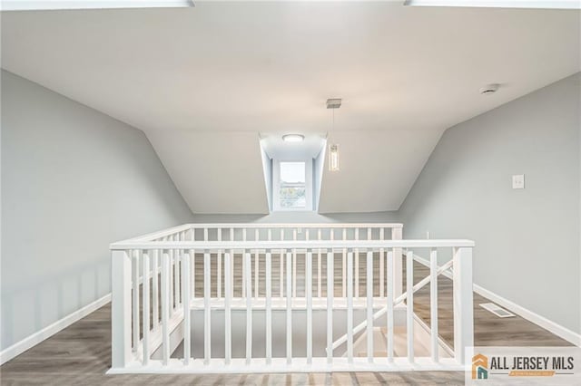 interior space featuring hardwood / wood-style floors and vaulted ceiling